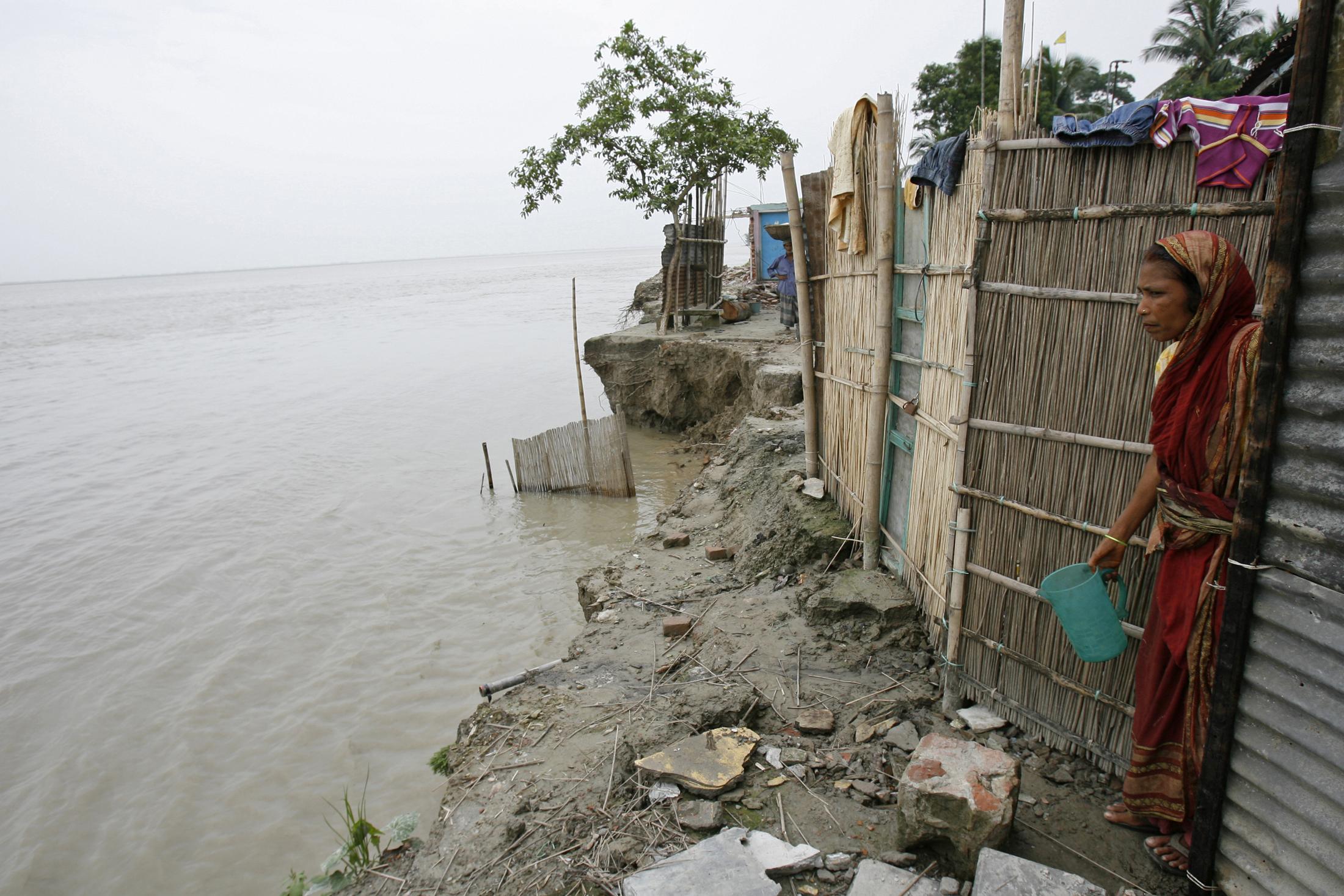 In this 2008 file photo, a woman looks at the River Padma from her house under threat from erosion of the river in Shariatpur, Bangladesh. REUTERS/Andrew Biraj
